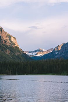 Tranquil mountain lake with forests and distant peaks in Bozeman, Montana. Perfect for nature lovers.