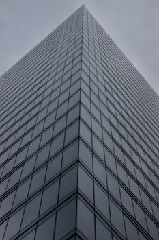 Dramatic low-angle view of a tall skyscraper in Brussels, Belgium, with reflective windows.