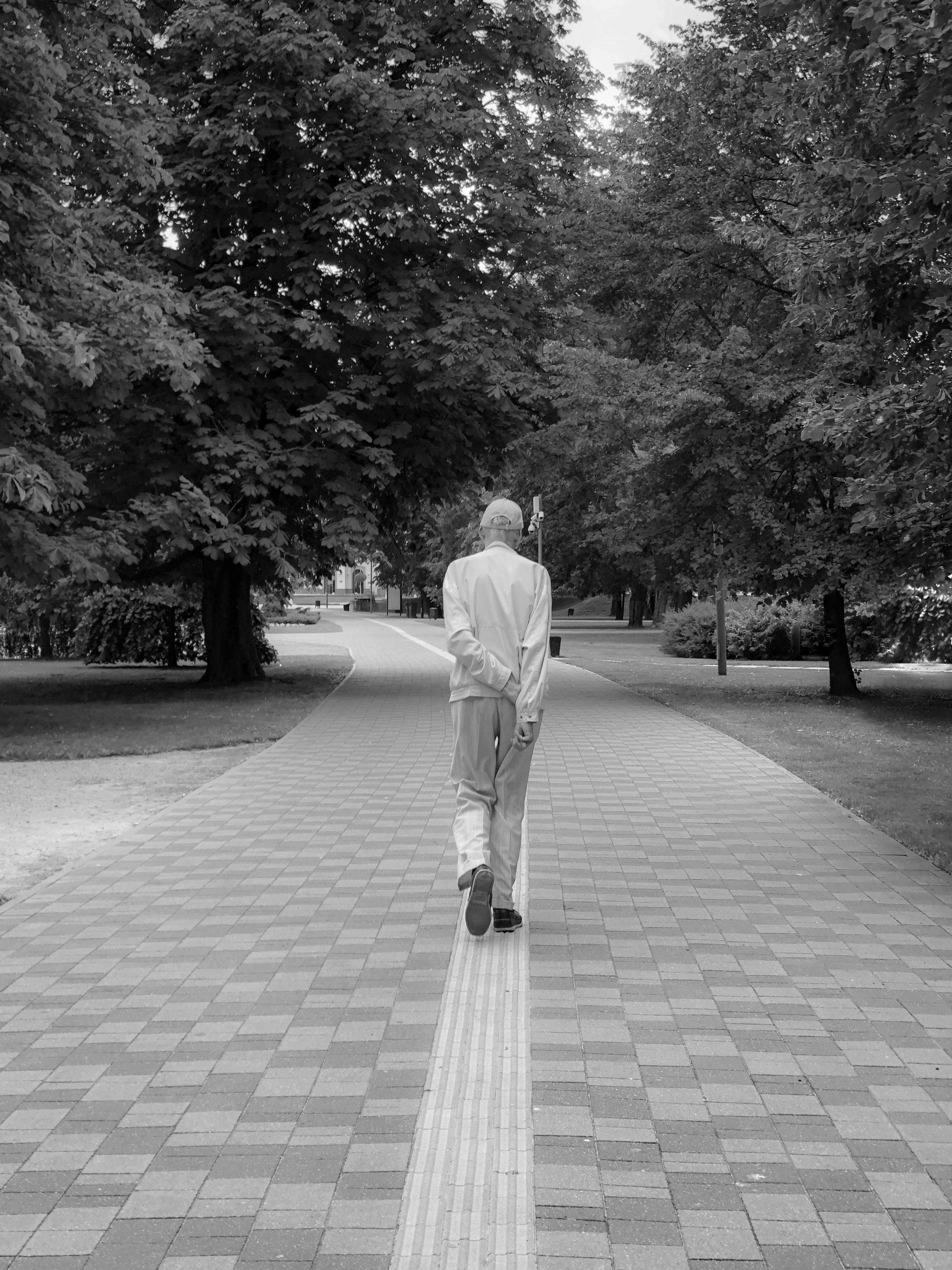 Elderly Man Walking at Park in Black and White · Free Stock Photo