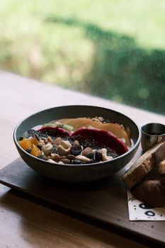 Close-up of a nutritious breakfast bowl with vibrant fruits, nuts, and bread.