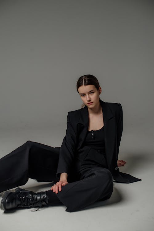 Woman Sitting and Posing in Black Suit