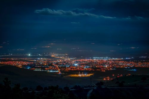Free Stunning nighttime aerial shot highlighting city lights and urban sprawl under a dark sky. Stock Photo