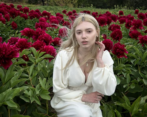Blonde Woman Posing among Flowers