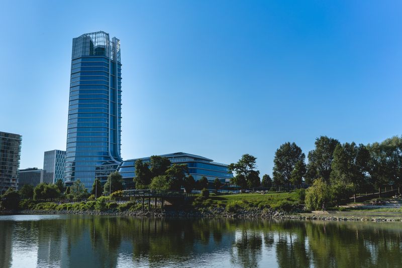 Glass office tower in Bellevue rising above a pond and green parkland