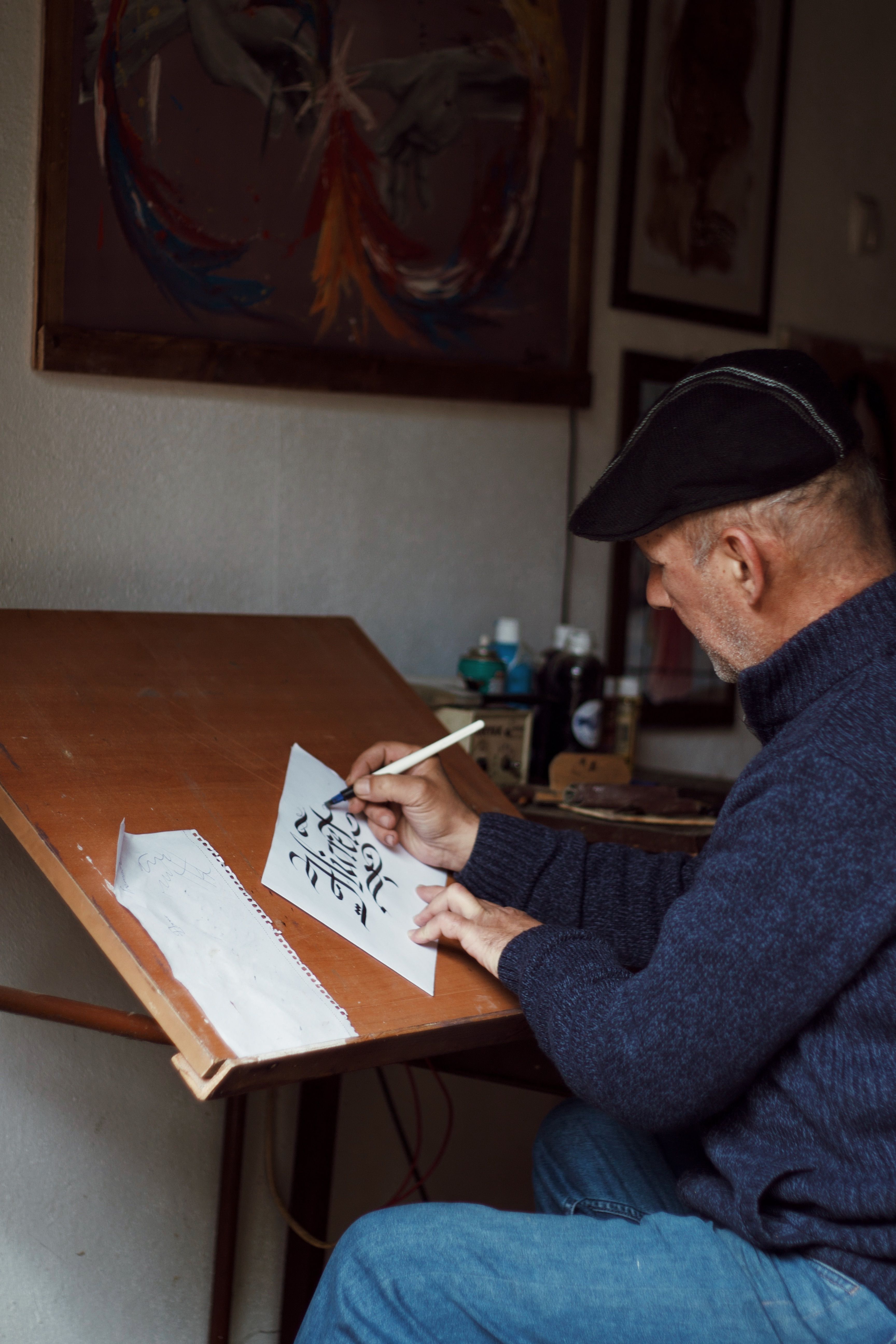 Elderly man drawing in an art studio, showcasing dedication and creativity.