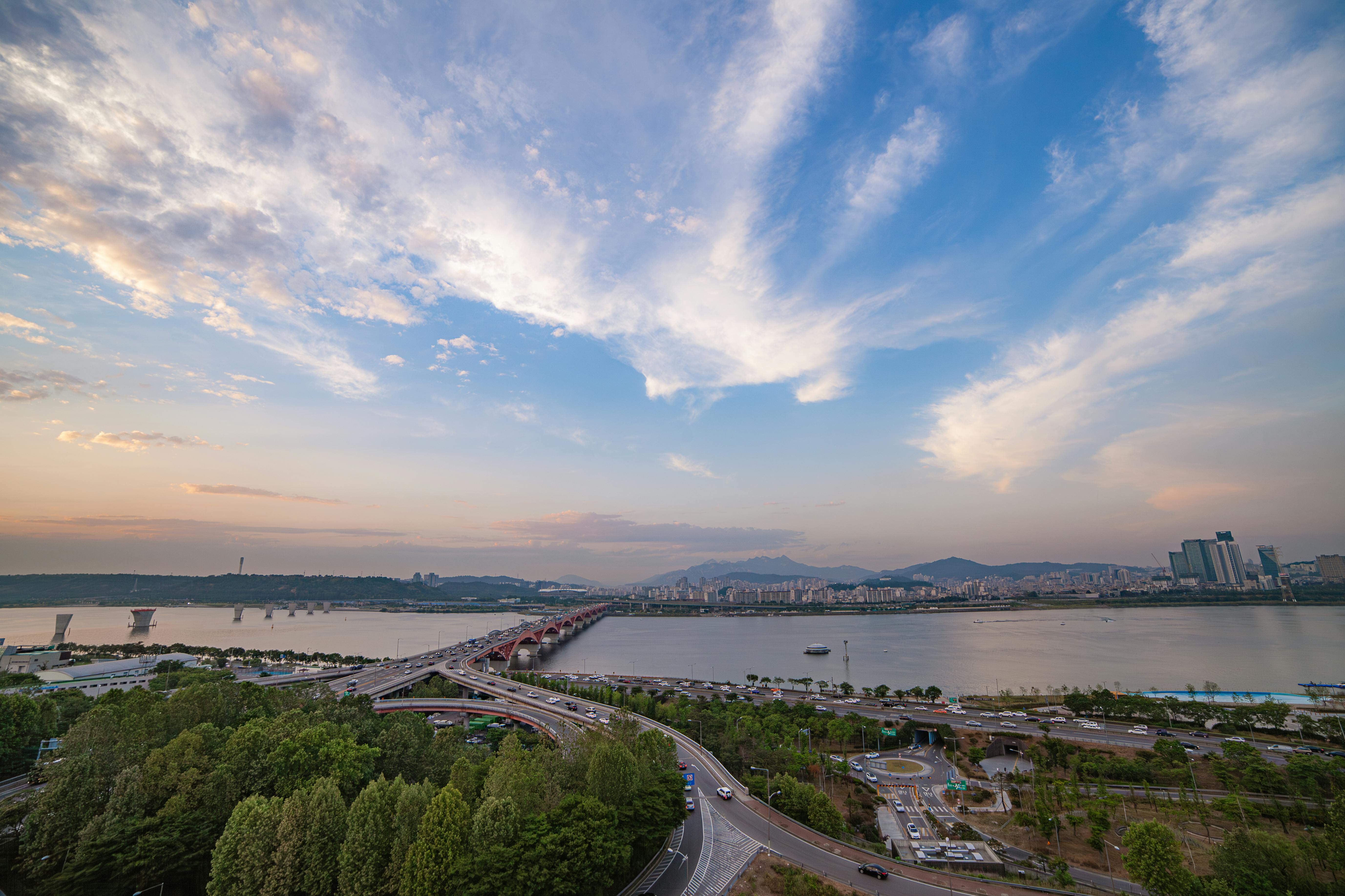 city with bridge over river at sunrise