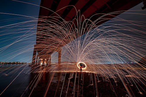 Person Spinning Steel Wool under the Bridge at Night