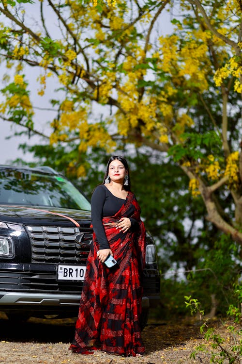 Woman in Traditional Indian Clothing Standing in front of a Car 
