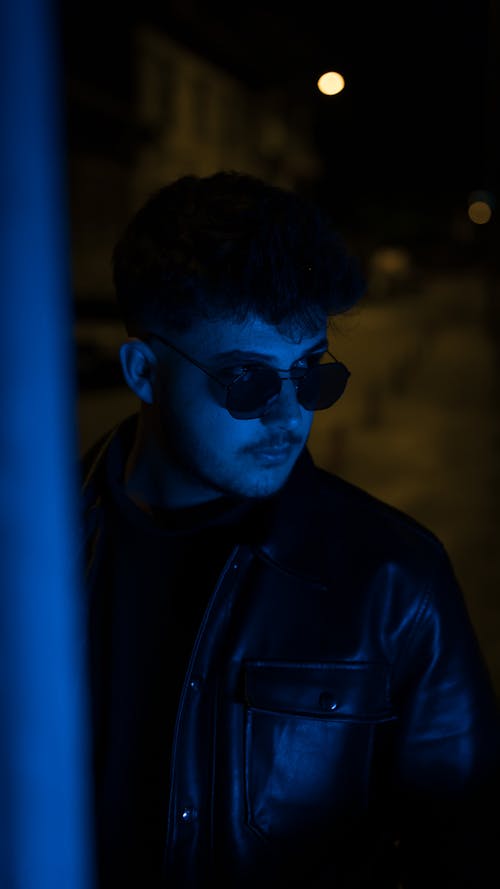 Man in Sunglasses and Leather Jacket at Night