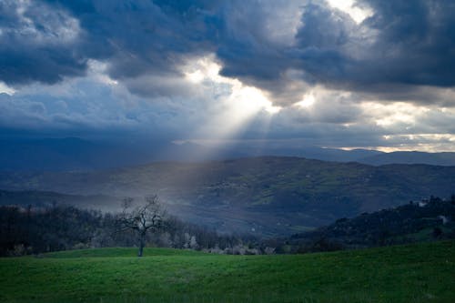 Sunbeams between Storm Clouds over Mountains