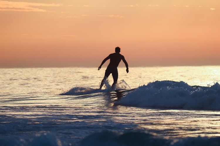 Surfing At Sunrise In Deal Beach, NJ