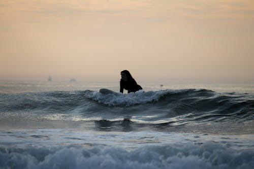 Woman Surfing on Wave on Sea Shore