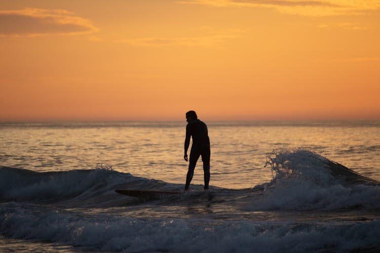 Surfing At Sunrise In Deal Beach, NJ