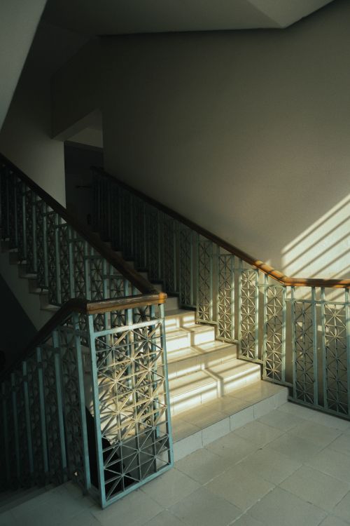 Free A beautifully lit staircase indoors with contemporary design and intricate metal railings. Stock Photo