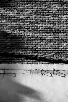 Detailed black and white image of a brick wall with shadow play and texture.