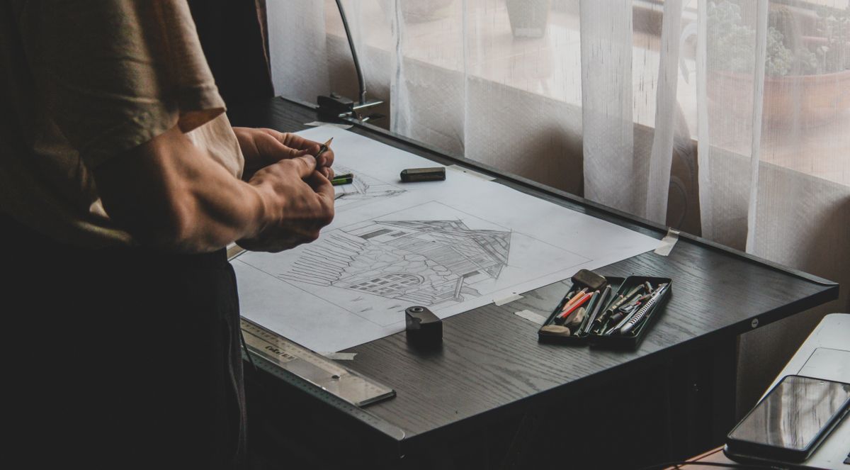 Arquitecta revisando planos sobre la mesa de trabajo