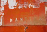 特写镜头下，生锈的橙色金属门油漆剥落，纹理清晰可见