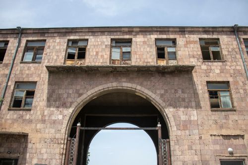 Free A historical stone archway and building facade against a blue sky, showcasing urban architecture. Stock Photo