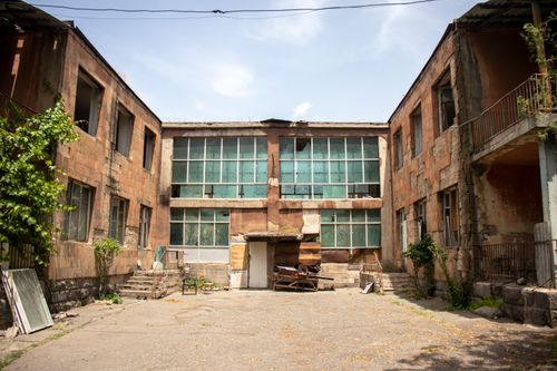Free An old, decaying urban courtyard with abandoned buildings, showcasing architectural neglect. Stock Photo