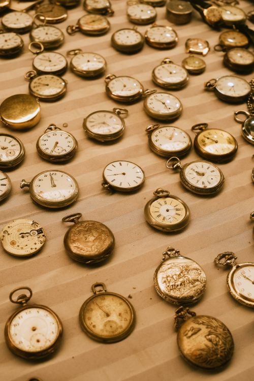 Free A collection of vintage pocket watches displayed on a striped surface, showcasing timeless elegance. Stock Photo