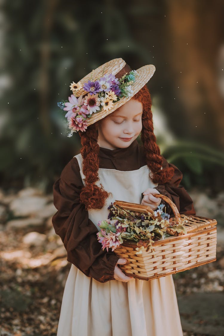 A Girl In A Hat Holding A Basket With Flowers