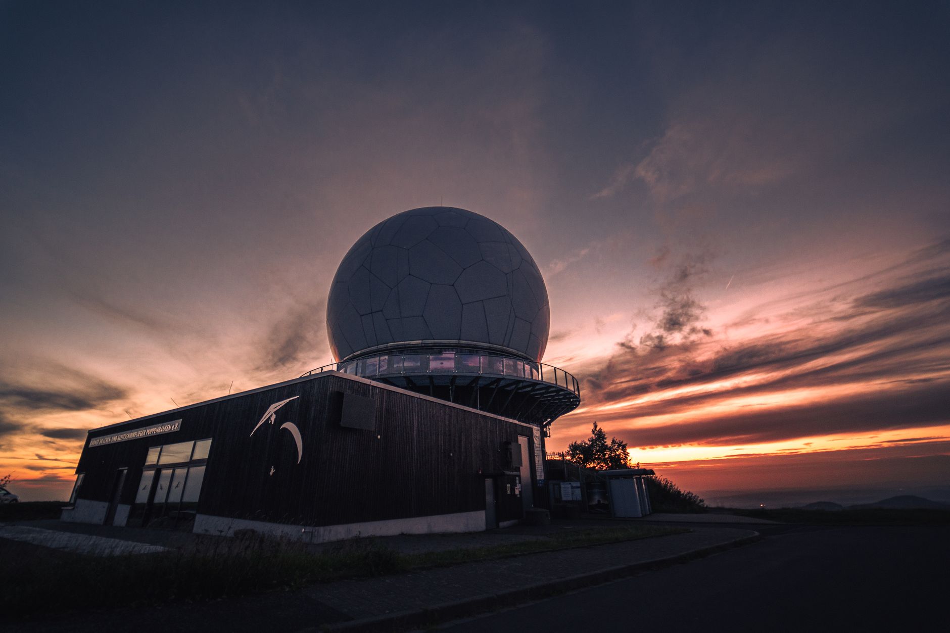 A radar dome at Wasserkuppe, Germany silhouetted against a stunning sunset sky.