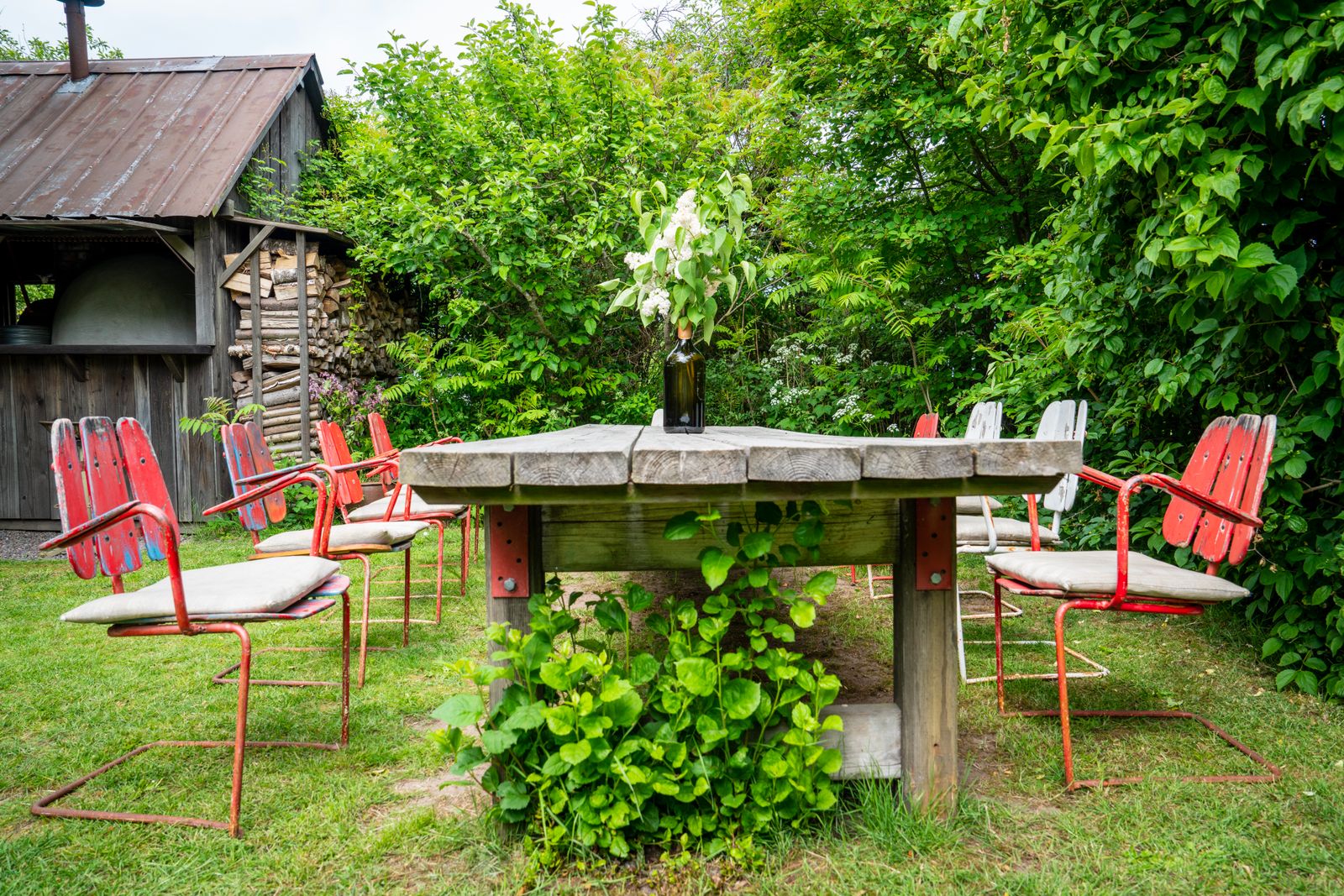 Table de jardin rectangulaire en teck dressée pour 8 personnes sur une terrasse