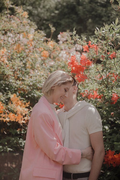 A Couple Hugging and Smiling in the Garden 