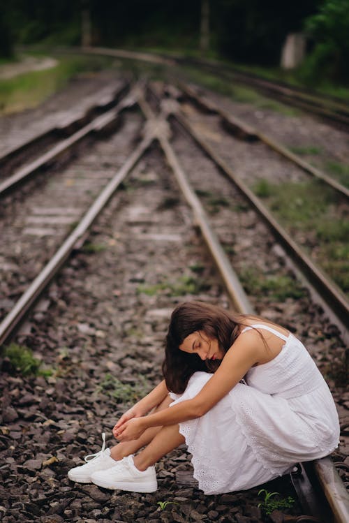 Model in White Dress Posing at Railway Tracks