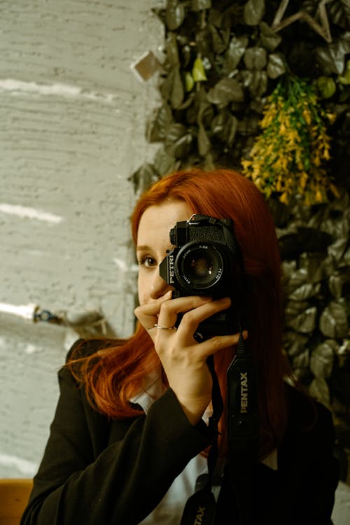 Young Woman Taking a Picture with a Film Camera 