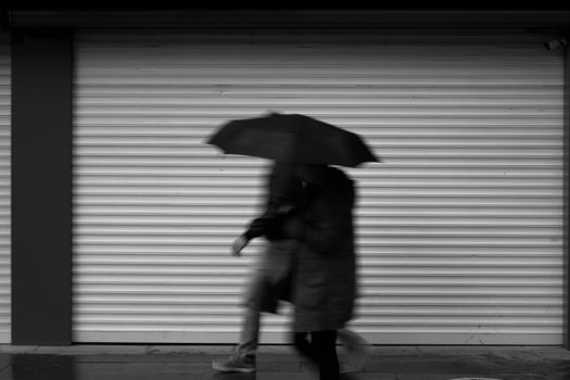 Blurred People Walking with Umbrella