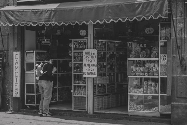 Woman Stands By Store Entrance