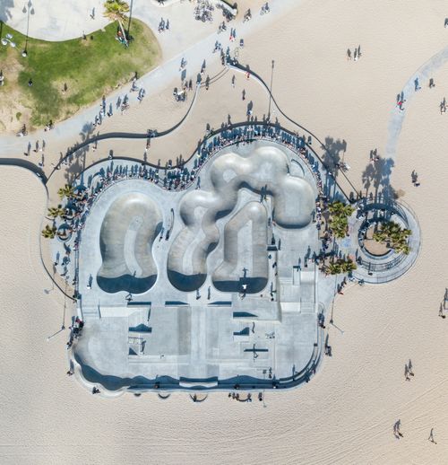 Free High-angle photo of a skatepark on a sunny beach, bustling with activity and surrounded by sand. Stock Photo