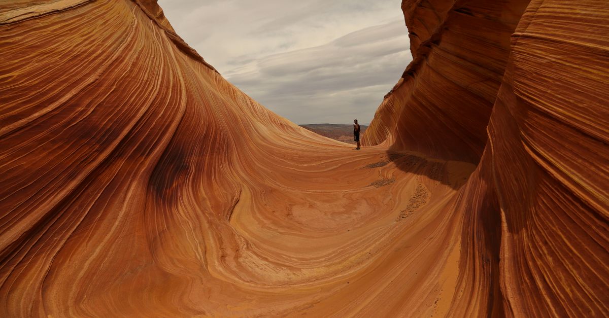 Red Wave Rocks Arizona Man Visiting The Wave Rock in Arizona · Free Stock Photo