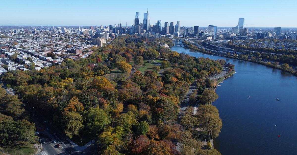 Stunning aerial shot of Philadelphia's skyline with Fairmount Park and Schuylkill River in fall colors.