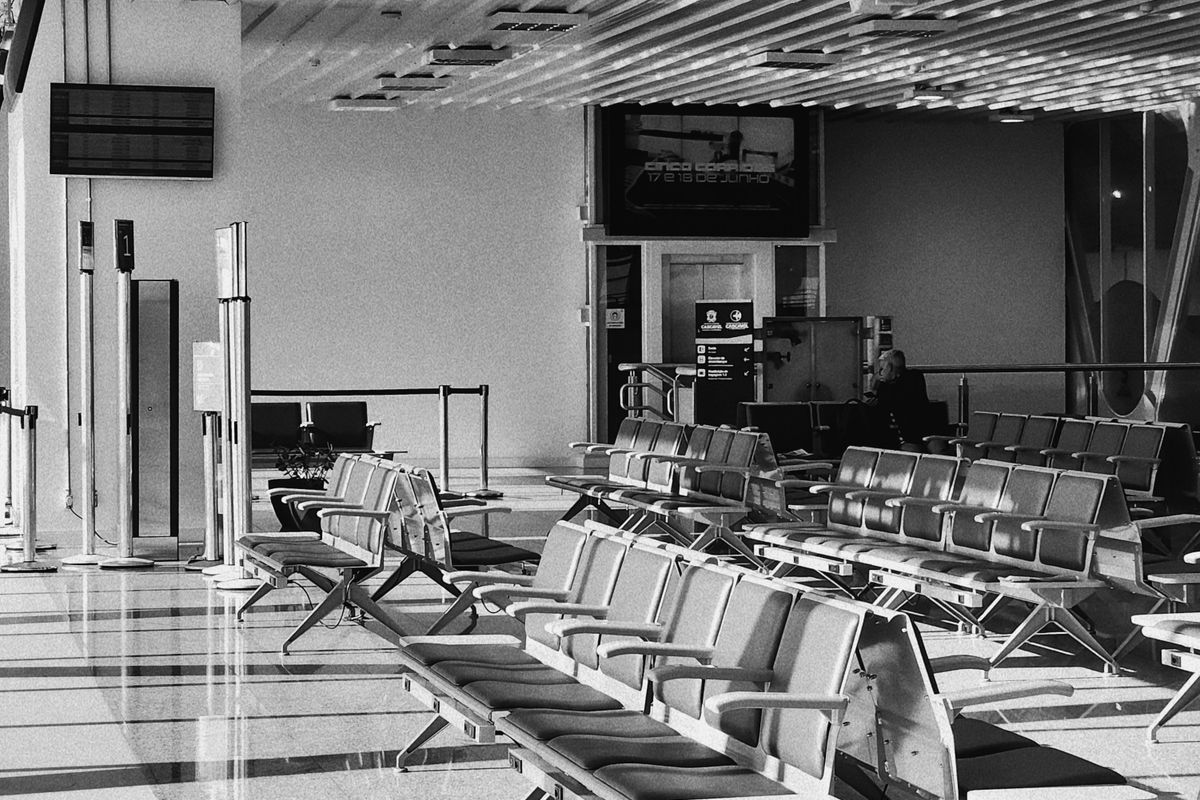 Quiet airport departure area with rows of seats