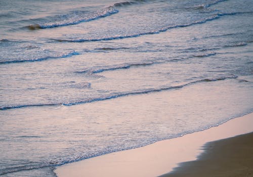 A person walking on the beach with a surfboard