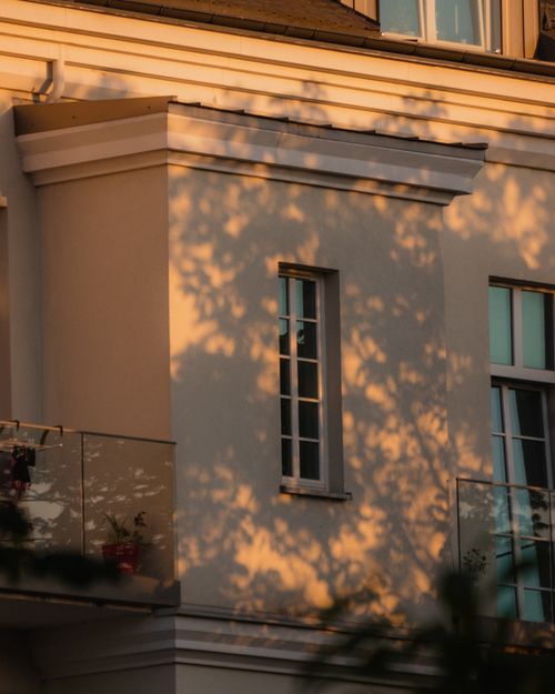 Free A peaceful evening view of a residential building with sunlight casting shadows on the facade. Stock Photo