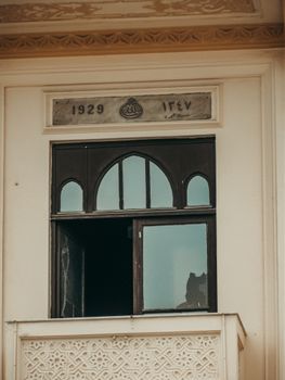 Close-up of a historic building window with distinct architectural design from 1929.