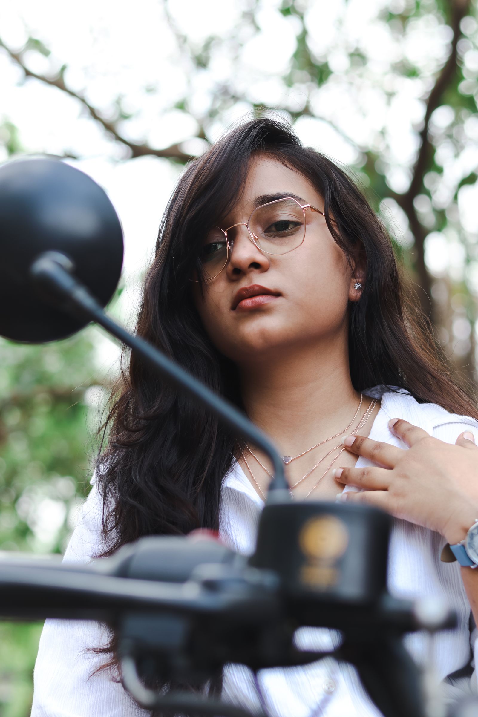 Woman in eyeglasses beside a motorbike