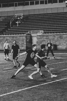 Players engaged in an intense black and white football game, showcasing athleticism on the field.