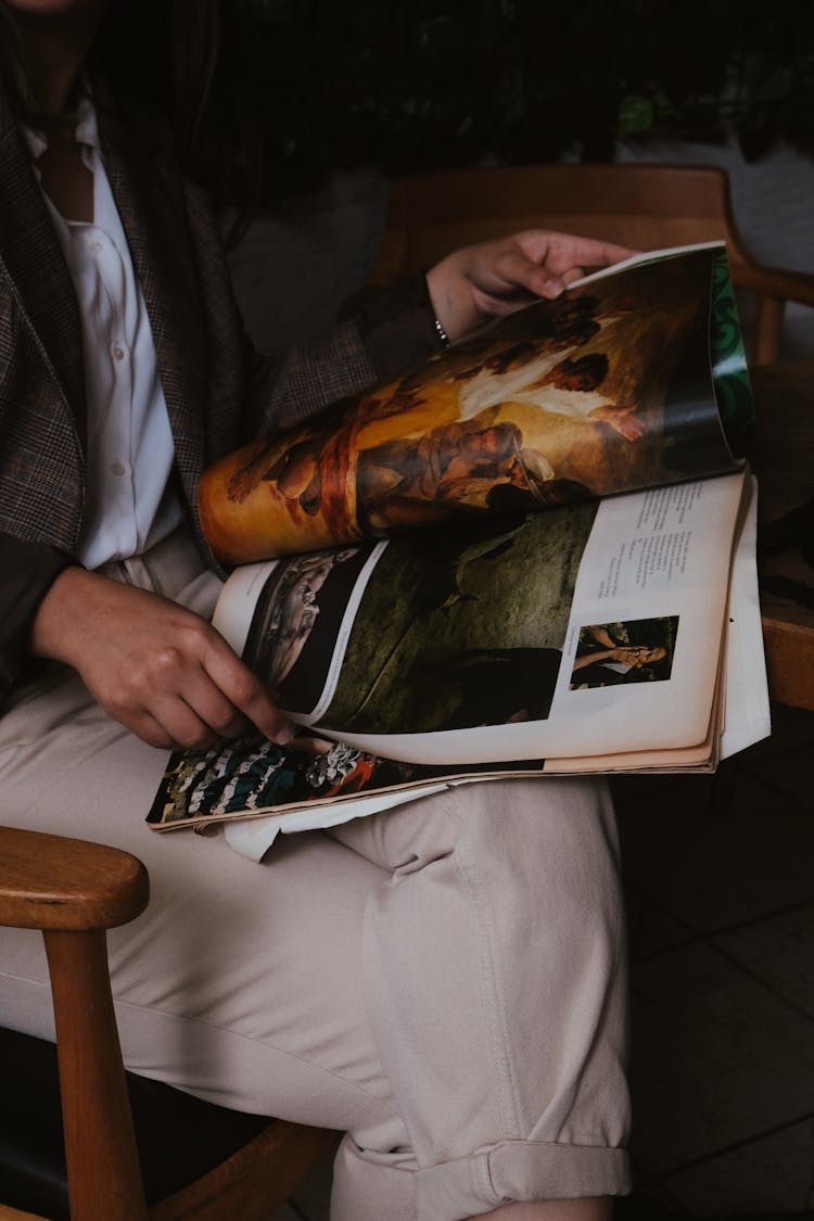 Person Sitting And Reading Magazine