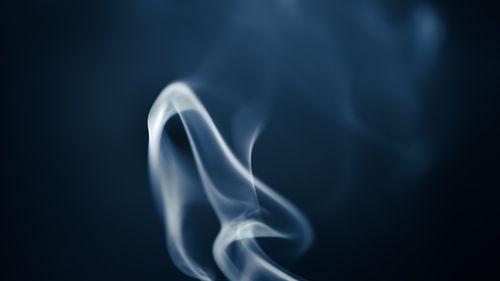 Free Artistic image of smoke swirling gracefully in contrast to a dark backdrop. Stock Photo