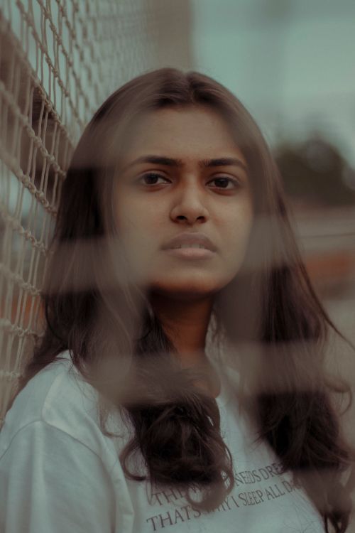 Free Captivating portrait of a young woman with netting effect, showcasing thoughtful expression. Stock Photo