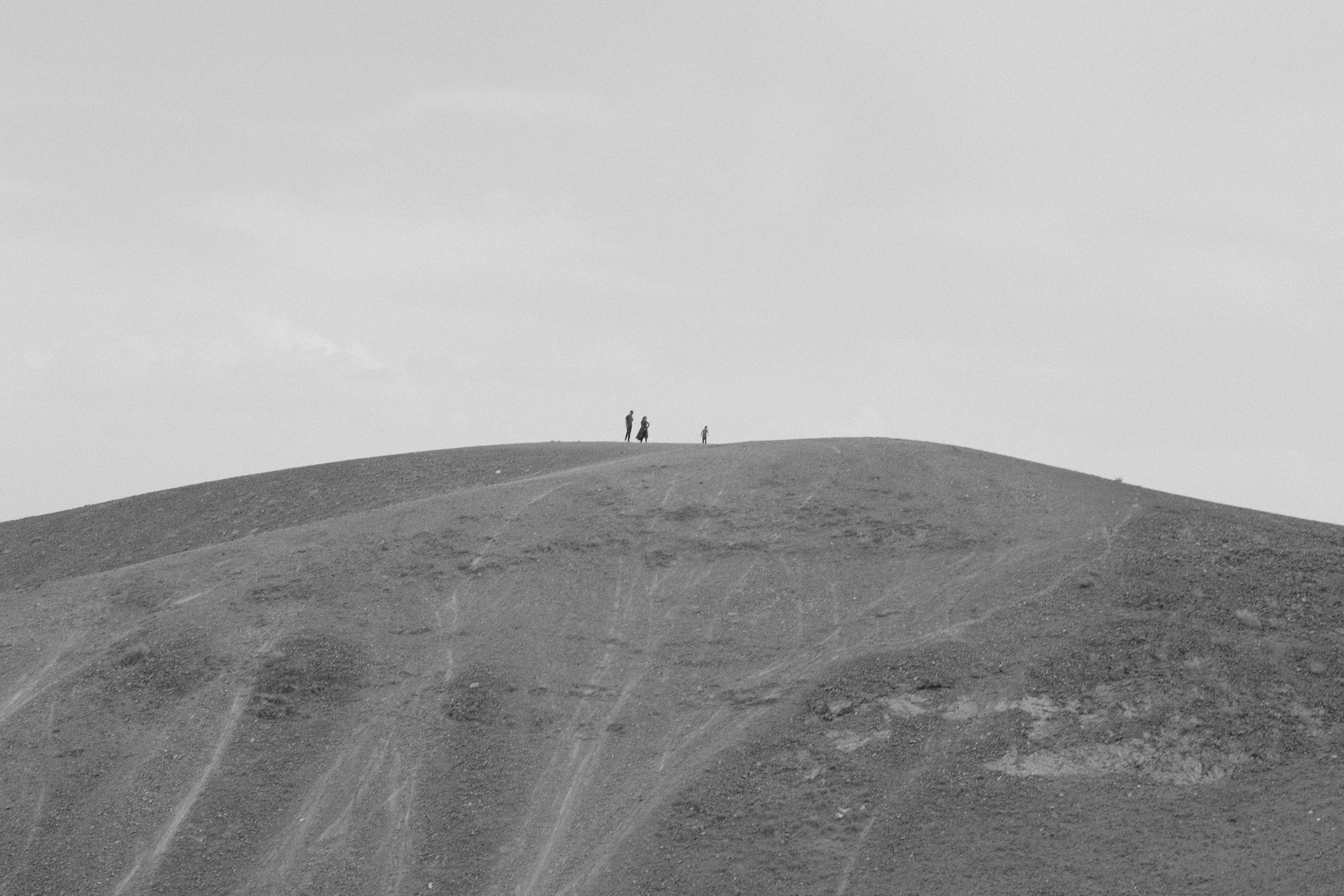 Minimalist black and white photo of people on a barren hill in Iran.