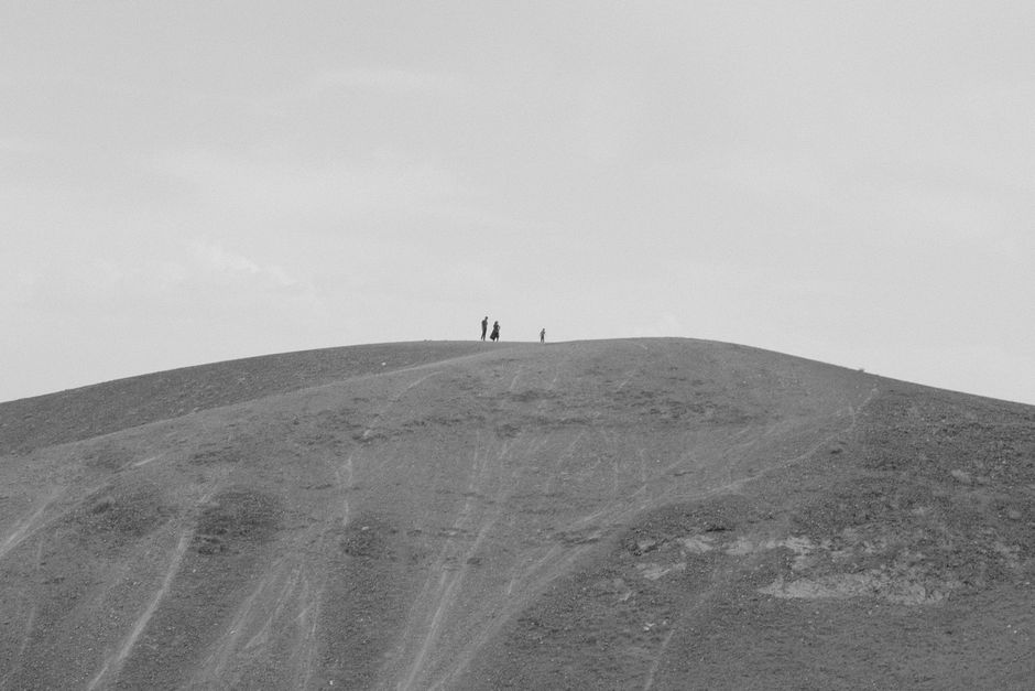 Minimalist black and white photo of people on a barren hill in Iran.