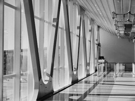 Black and white photo of a modern airport corridor with unique architecture and natural light.