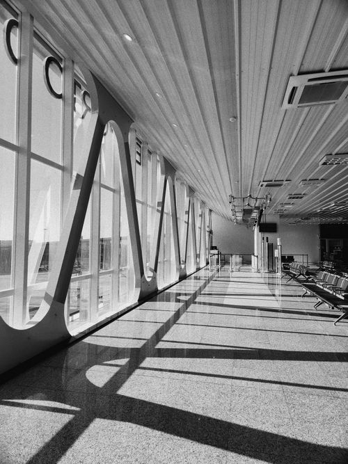 Free Spacious airport waiting area with large windows and modern design features Stock Photo