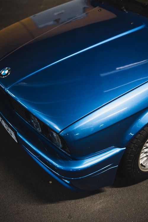 Free Close-up of a classic blue car parked on city streets. Perfect for automotive enthusiasts. Stock Photo