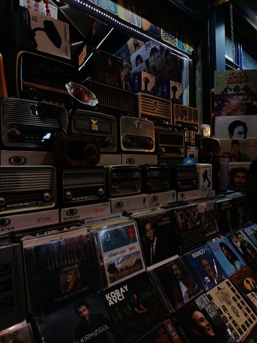 Free Explore a retro music store with vintage radios and a diverse CD collection in a nostalgic setting. Stock Photo